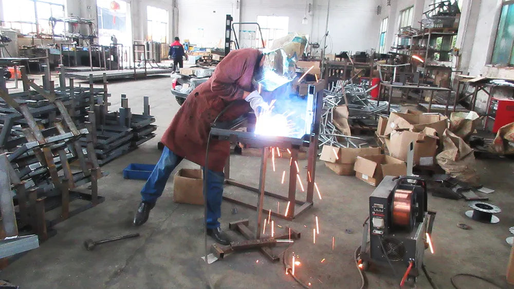 Robotic welding arm applying precise welds to a chassis frame at Suncart factory